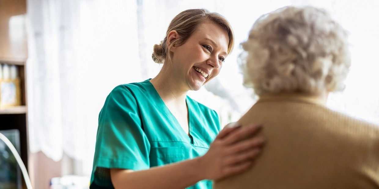 Pflegekraft kümmert sich um Dame in ihrer Wohnung